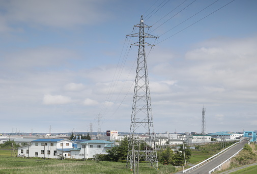 Transmission towers stand near a bridge in Oroshi Center, Hachinohe, Aomori Prefecture. Spring afternoon with clouds in the northern Tohoku Region.