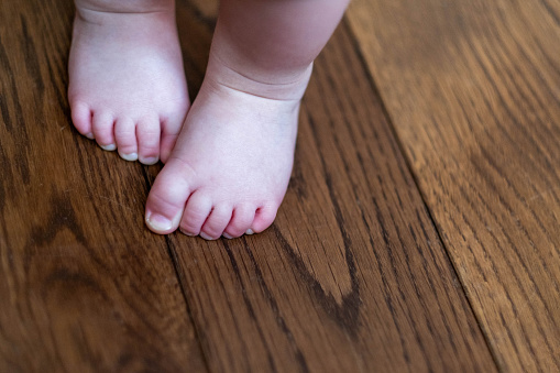 the feet of a small child on the wooden floor