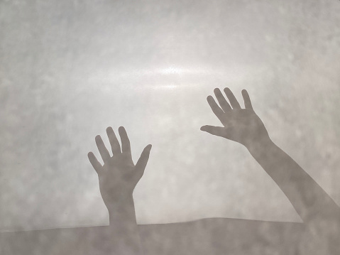 Shadow hands through glass, faceless person, fear