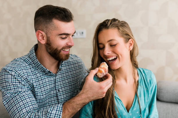 istock Young couple eating snack at home 1661815078