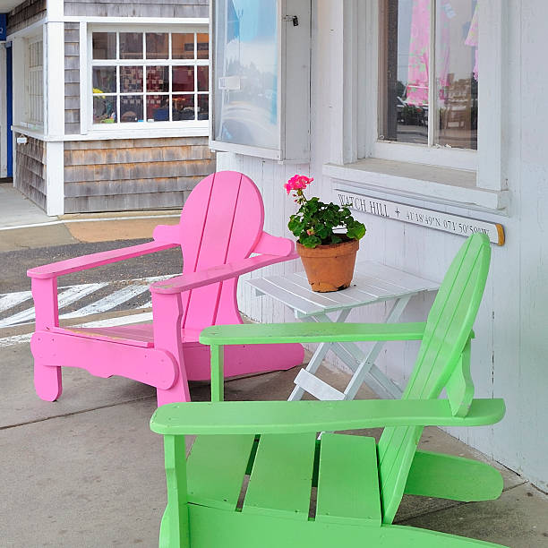 Bright pink and green Adirondack Beach Chairs, Watch Hill, RI Colorful pink and lime green beach chairs a/k/a Adirondack chairs in Watch Hill, Rhode Island, United States USA with potted plant (geranium) as symbol of relaxation, summer and small town America. westerly rhode island stock pictures, royalty-free photos & images