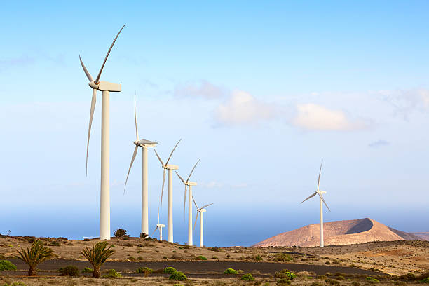 istock Wind farm power generator with vulcan on background 166182536