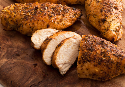 Grilled Boneless Chicken breasts, on wood cutting board.