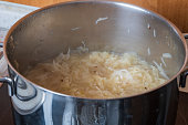 Sauerkraut in a pot on the stove. There is cumin in cabbage