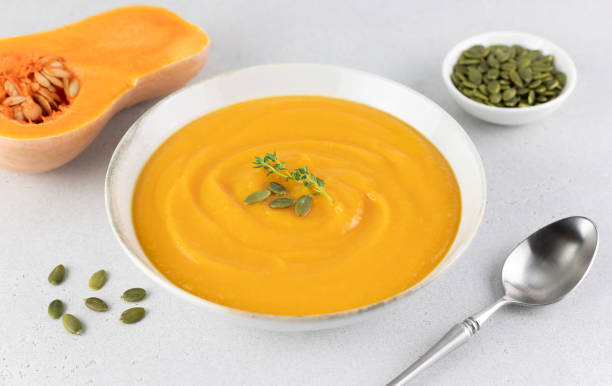 istock Pumpkin soup puree with creamy texture and pumpkin seeds on a gray background. 1661880797