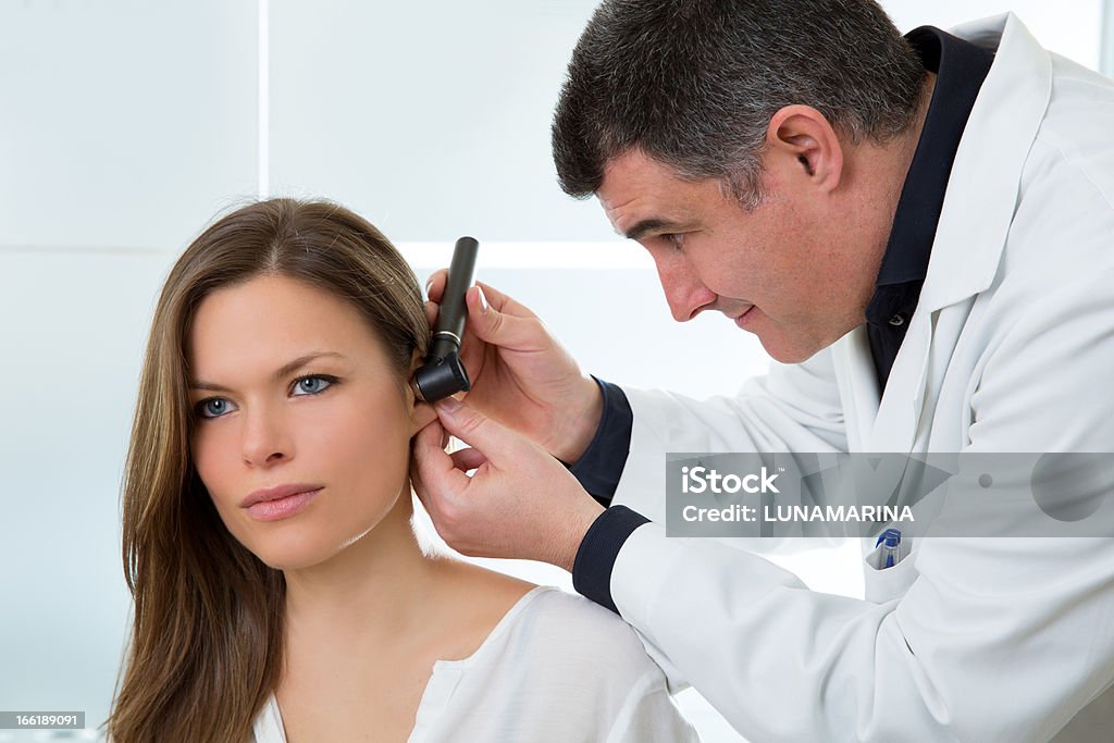 Doctor ENT checking ear with otoscope to woman patient Doctor ENT checking ear with otoscope to woman patient at hospital Adult Stock Photo