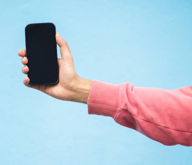 istock Man, hand or phone screen mockup on isolated blue background in social media, app or blank web design. Zoom, student or model person with technology mock up for city contact communication or branding 1661907658