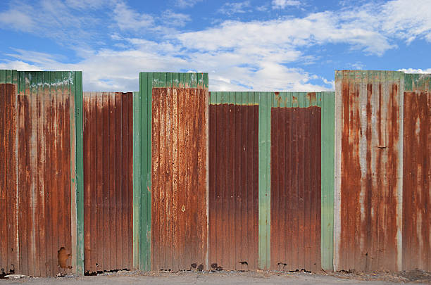 istock zinc fence on blue sky background 166190965