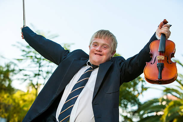 istock Friendly handicapped boy raising violin outdoors. 166191197