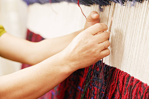 Woman hands weaving carpet stock photo