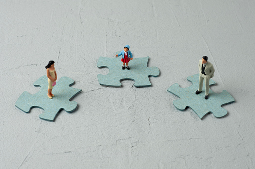 Family figurines stand on puzzles