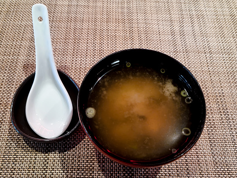 Japanese Omakase meal: Miso soup in miso black and gold color bowl close with a lid on the counter. Japanese traditional and luxury meal.