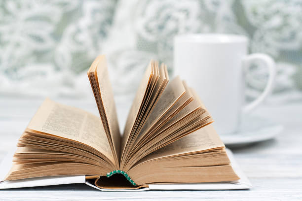 istock Open hardback book, cup on wooden table. natural background . Back to school. Copy space for text. 1661946862