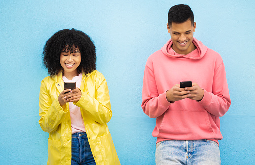 Happy couple, bonding or phone typing on isolated blue background on social media, 5g dating app or travel networking. Smile, man or black woman on mobile technology for community networking website