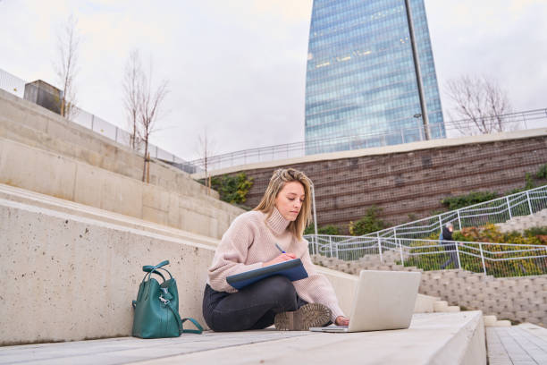 istock teenager girl student using laptop computer modern technology device outdoor in university campus online learning, learning outside sitting on urban stairs. Web education course webinars concept. 1661996909