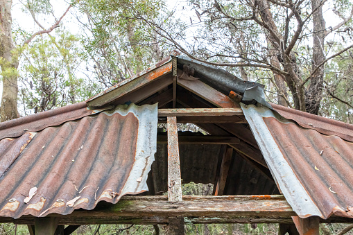 Photograph of an old brown rusty and damaged roof on an explorers hut in The Blue Mountains in New South Wales in Australia