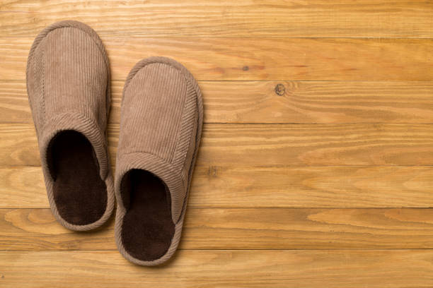 istock Man's slippers on wooden background, top view 1662016987