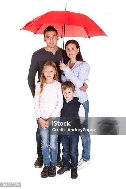 Felice Giovane Famiglia In Piedi Sotto Un Ombrello - Fotografie stock e altre immagini di Ombrello - Ombrello, Famiglia, Sotto