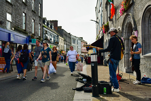 Buskers playing on Shop Street in Galway as pedestrians walk by