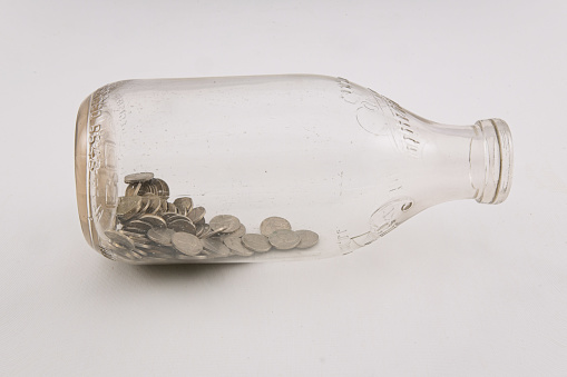 Coins in a glass bottle used as a bank.