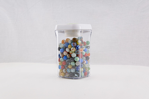 Toy glass marbles stored in a clear plastic container