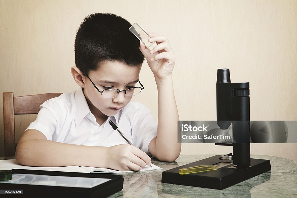 Niño en edad escolar haciendo su hoomwork - Foto de stock de Aprender libre de derechos