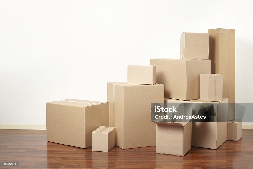 Brown cardboard boxes of various sizes piled together Cardboard boxes in apartment, moving day Moving Office Stock Photo
