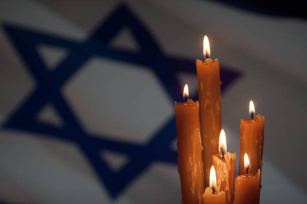 istock Six burning candles on Israel flag background. 1662079837