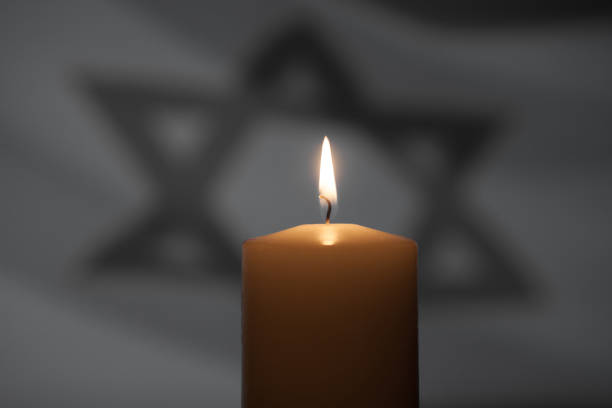istock Burning candle on Israel flag background. 1662080390