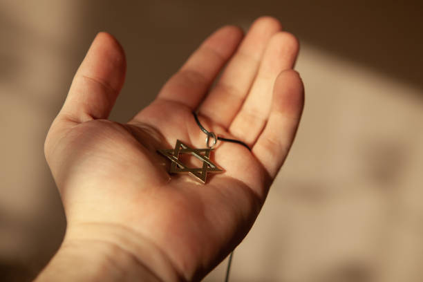 Closeup of pendant in the shape of the star of David on the hand of a man. stock photo
