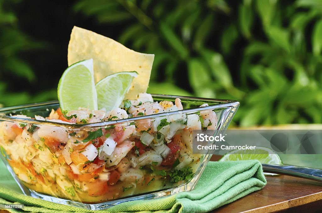Ceviche in a bowl with lime on a wooden table Fresh Mexican Ceviche with lime. Seviche Stock Photo