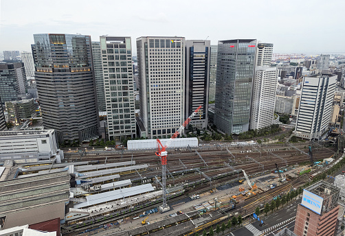 Minato, Japan - June 10, 2023: Foreground shows the ongoing renovations of Shinagawa Station. Corporate towers stand in the Konan District to the east. Spring early evening in the Tokyo Metropolis.