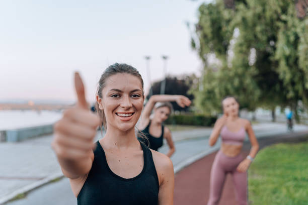 istock Three women in workout attire perform stretching exercises on a jogging track, highlighting the camaraderie and motivation that come with group fitness 1662123003