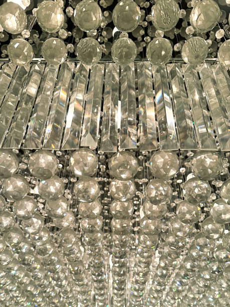 Full frame image of crystal chandelier light with sparkling rectangular and spherical cut-glass, viewed from below, wall paper background