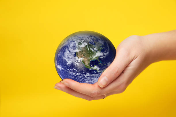 istock Defocus female hand holding planet globe on yellow background. Environmental protection concept. Earth in hands. Save of Earth. Elements of this image furnished by NASA. Out of focus 1662134765