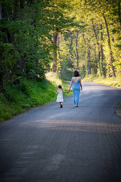 istock Mother Leading Daughter Down Country Road 166213883