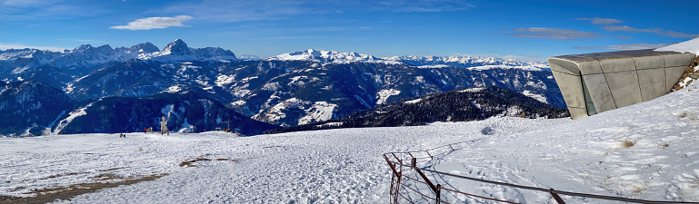 Plan de Corones, Italy - January, 30, 2023: Panoramic view from top of Kronplatz with Messner Mountain Museum Corones, Italy in winter against blue sky with clouds