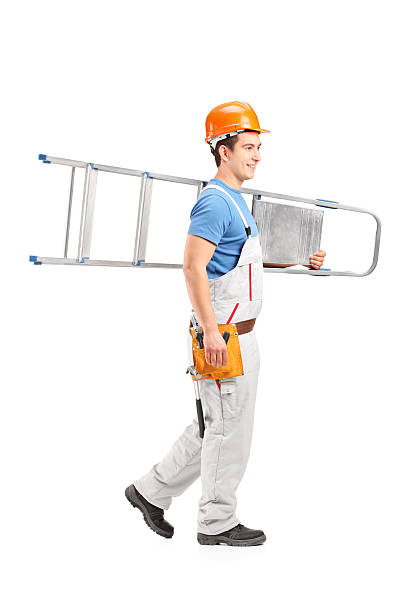 istock Repairman with a helmet carrying ladder 166223467