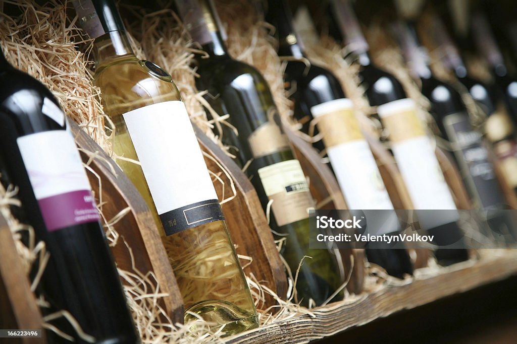 Closeup shot of wineshelf. Closeup shot of wineshelf. Bottles lay over straw. Wine Stock Photo