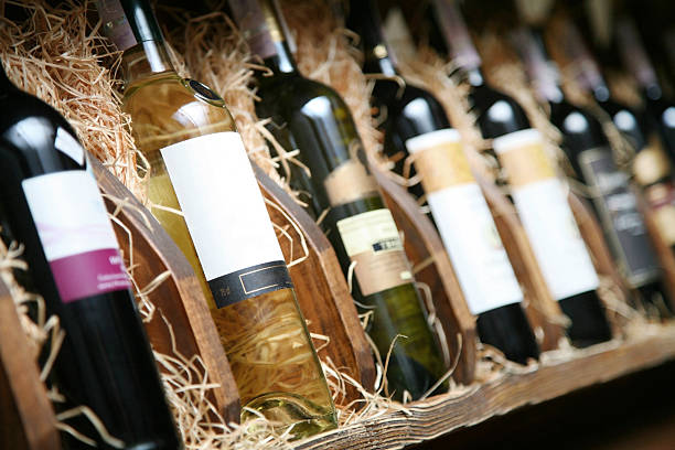 Closeup shot of wineshelf. Closeup shot of wineshelf. Bottles lay over straw. alcohol shop stock pictures, royalty-free photos & images