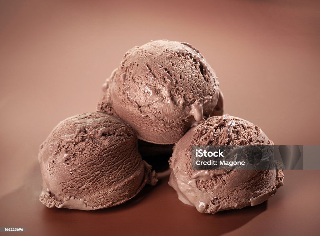 Gelato al cioccolato su Sfondo marrone - Foto stock royalty-free di Cucchiaiata