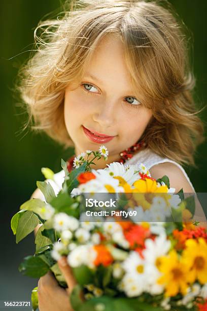 Sonriente Joven Con Ramo De Flores Silvestres Foto de stock y más banco de imágenes de Adolescente - Adolescente, Agarrar, Aire libre