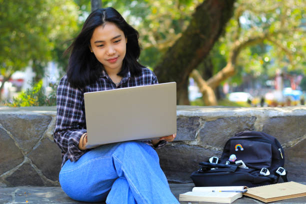 istock young smiling asian woman using laptop and writing notebook, cheerful asian student watching webinar and studying from e course 1662278423
