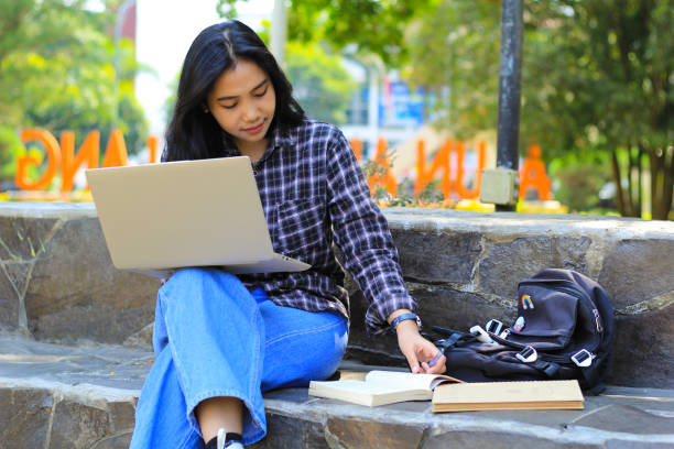 istock young smiling asian woman using laptop and writing notebook, cheerful asian student watching webinar and studying from e course 1662281123