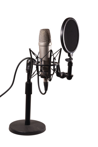 A condenser microphone with shock mount and pop shield in a desk stand isolated over white background, with clipping path