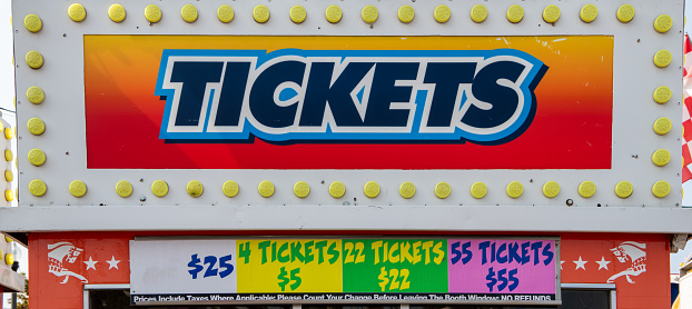 Ticket sign with yellow lights at amusement park