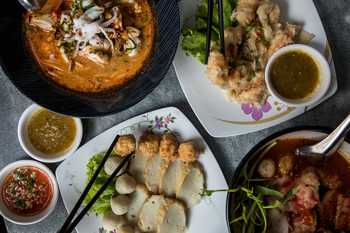 Thai food, noodles, fish balls on the dining table with side dishes, street food