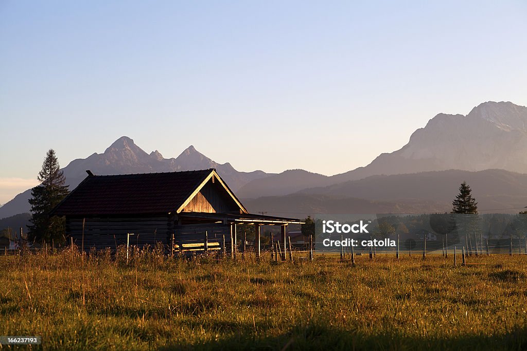 wooden hut in mountains wooden hut in mountains at sunset Agricultural Field Stock Photo