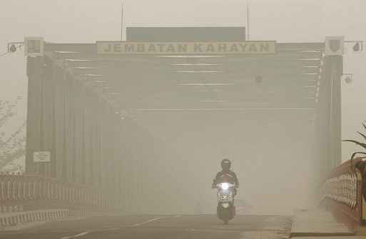 Motorists cross the Kahayan bridge road in Palangka Raya, Central Kalimantan Province, Indonesia which is shrouded in smoke haze due to forest fires.