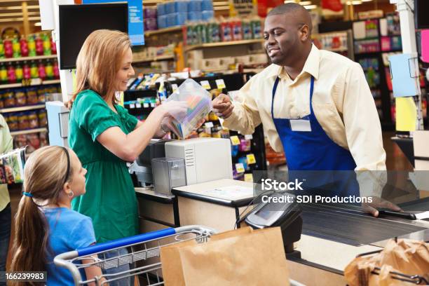 Mom Shopping For Groceries With Daughter Checking Price On Item Stock Photo - Download Image Now